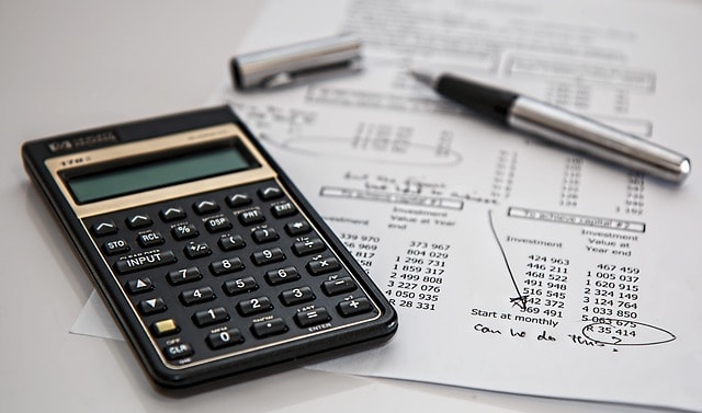 Taxes being calculated. A pen is over the form and next to it a calculator