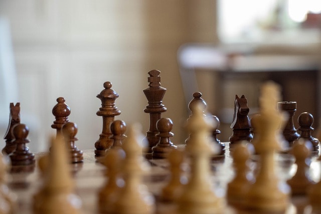 A chessboard with chesspieces orderly arranged.